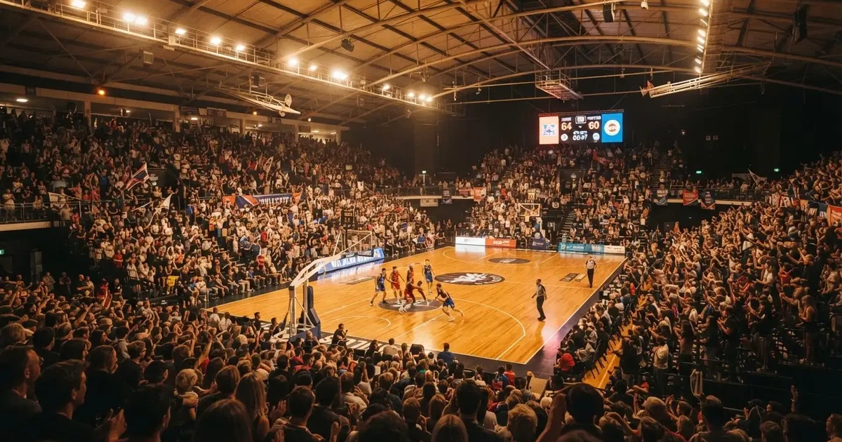 Un pabellón deportivo lleno bajo los focos, fotografiado desde muy lejos