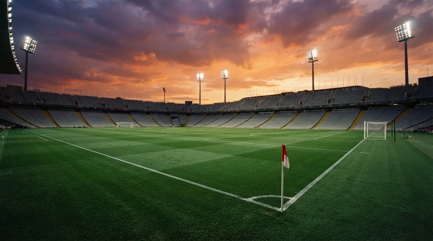 Un estadio de fútbol vacío con torres de iluminación al atardecer