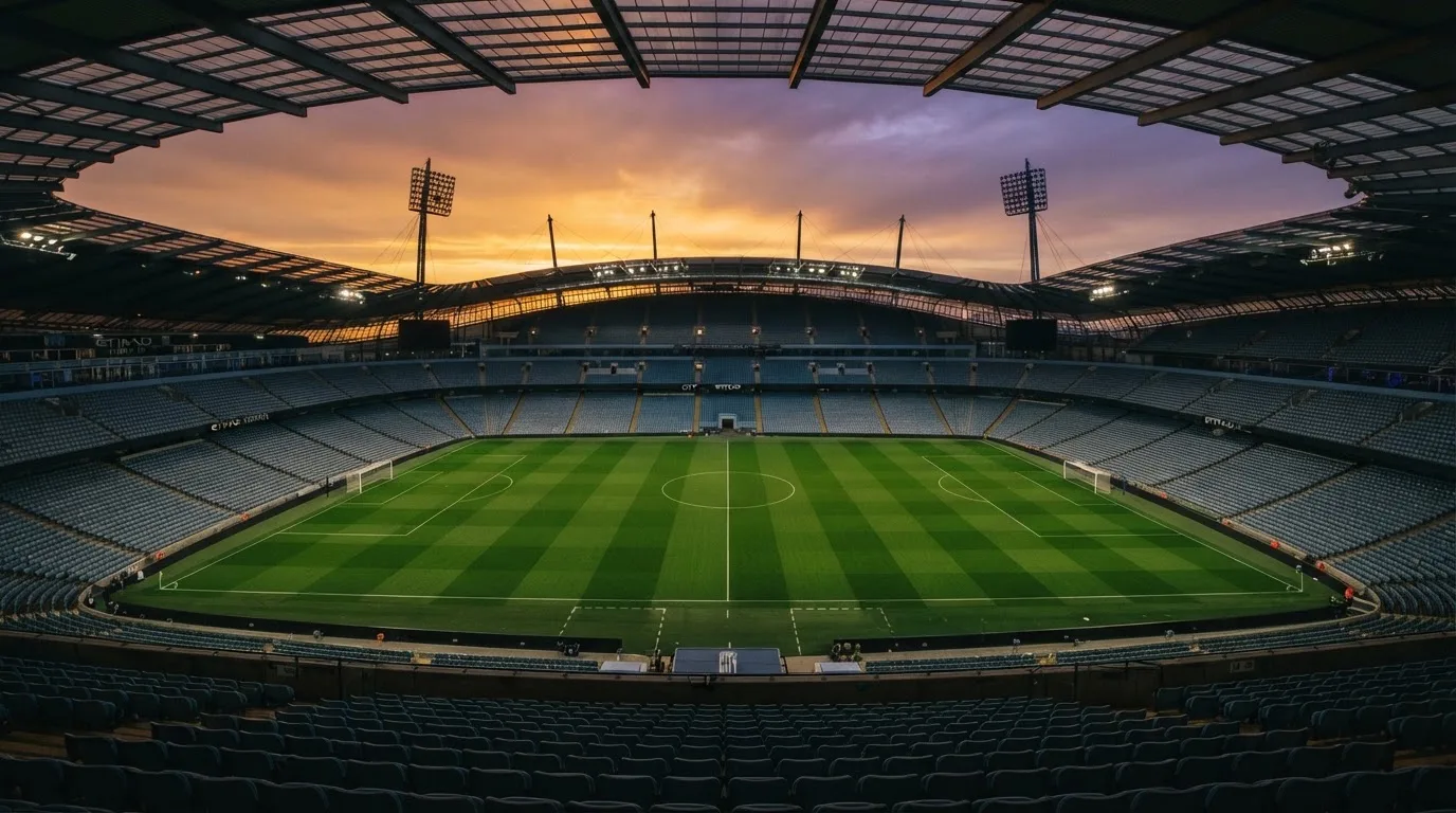 Un estadio de fútbol vacío con torres de iluminación al atardecer